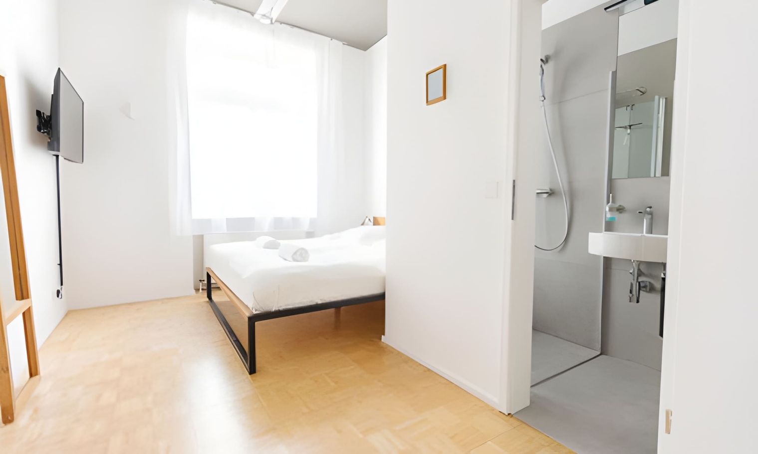 Chambre lumineuse et moderne avec une salle de bains à l'arrière-plan.