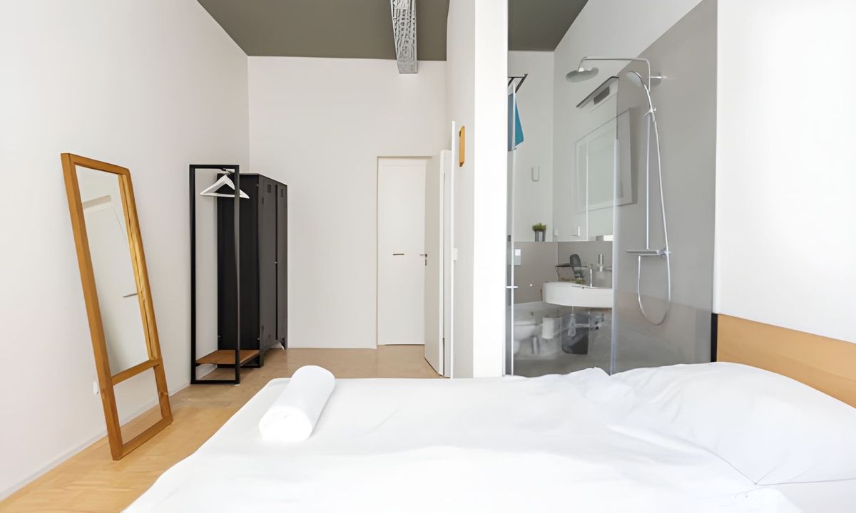 Modern bedroom with a large mirror and a wardrobe.