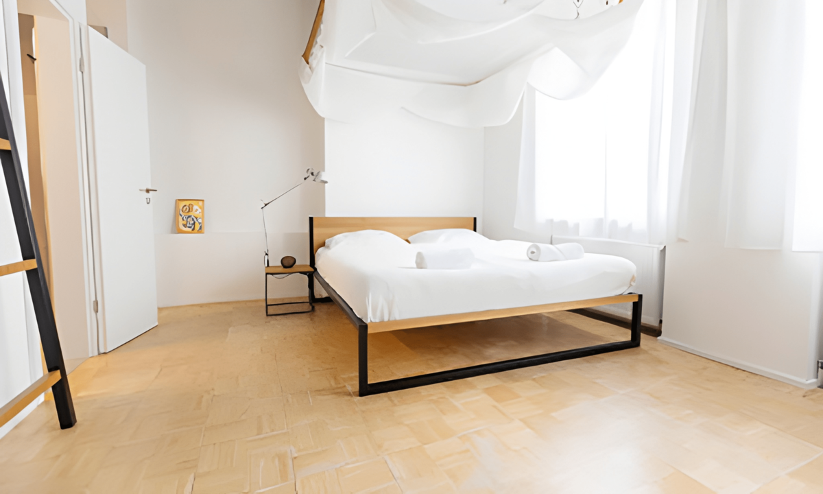 Helles, modernes Schlafzimmer mit einem großen Bett und minimalistischer Einrichtung.